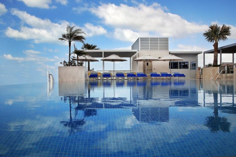 A Pool With Umbrellas And Chairs In It