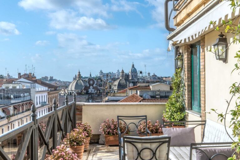 A Balcony With Chairs And Flowers On It